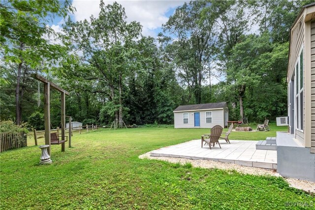 11911 Kilrenny Rd, Midlothian, VA 23113 - view of green lawn featuring an outbuilding, a patio, view of wooded area, and a fire pit