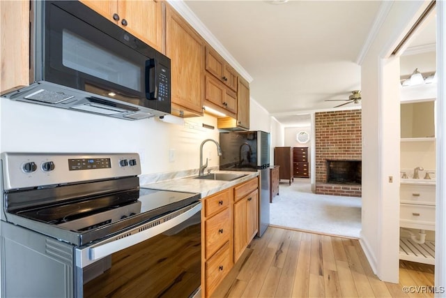 3513 Patrick Ave, Richmond, VA 23222 - kitchen with appliances with stainless steel finishes, a sink, light wood-style flooring, a ceiling fan, and a fireplace