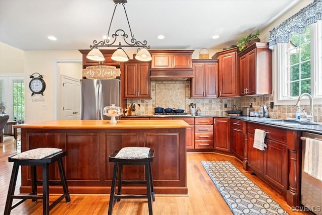 11470 Jack Ln, Hanover, VA 23146 - kitchen with appliances with stainless steel finishes, a sink, a center island, light wood-type flooring, and decorative backsplash