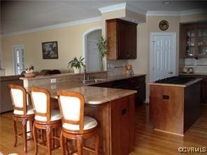 2401 Bell Tower Pl, Henrico, VA 23233 - kitchen with ornamental molding, wood finished floors, a kitchen island, a breakfast bar, and a sink