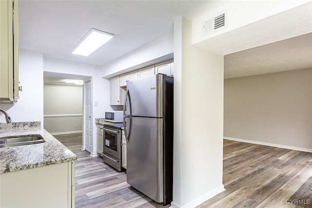 1500 Largo Rd Unit 201, Henrico, VA 23238 - kitchen featuring stainless steel appliances, a sink, light wood finished floors, white cabinets, and light stone countertops
