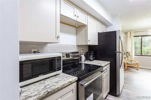 1500 Largo Rd Unit 201, Henrico, VA 23238 - kitchen featuring stainless steel electric stove, white cabinetry, backsplash, light wood-type flooring, and a textured ceiling