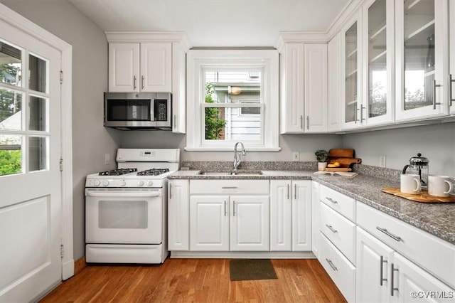 3204 Griffin Ave, Richmond, VA 23222 - kitchen featuring stainless steel microwave, white range with gas stovetop, a sink, white cabinetry, and light wood-style floors