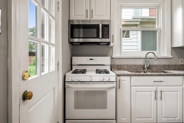 3204 Griffin Ave, Richmond, VA 23222 - kitchen featuring white range with gas stovetop, stainless steel microwave, a sink, and healthy amount of natural light