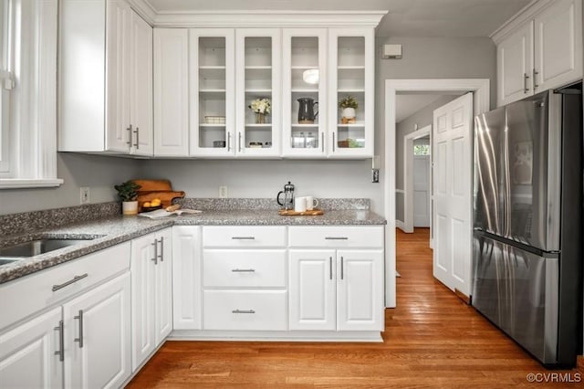 3204 Griffin Ave, Richmond, VA 23222 - kitchen with freestanding refrigerator, white cabinetry, light wood-style floors, and glass insert cabinets