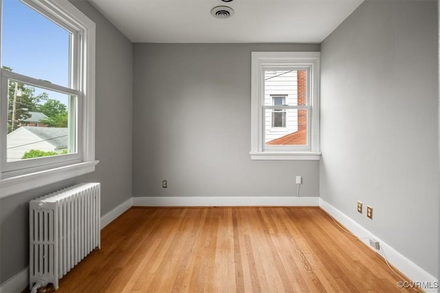 3204 Griffin Ave, Richmond, VA 23222 - unfurnished room featuring radiator, light wood finished floors, plenty of natural light, and baseboards