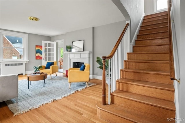 3204 Griffin Ave, Richmond, VA 23222 - living area with radiator heating unit, stairway, wood finished floors, a fireplace, and plenty of natural light