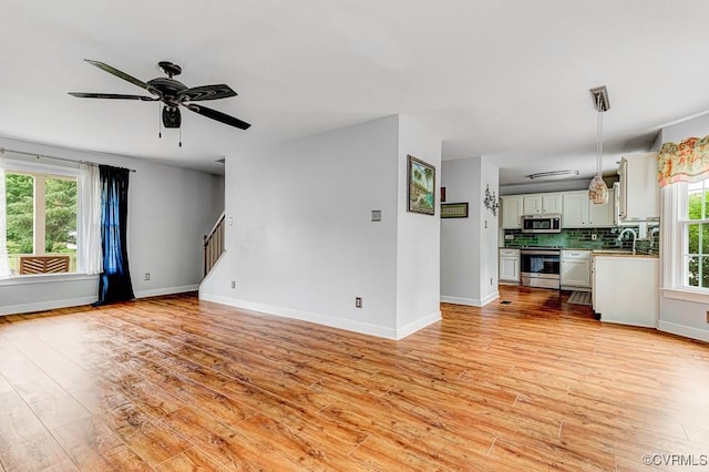 9214 Hunters Chase Dr, Mechanicsville, VA 23116 - unfurnished living room with healthy amount of natural light, light wood-style floors, a sink, and a ceiling fan