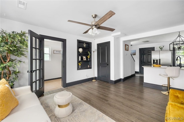327 S 12th Ave, Hopewell, VA 23860 - living area featuring a ceiling fan, dark wood-type flooring, baseboards, built in features, and a chandelier