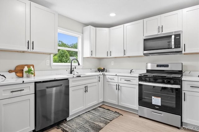 3207 Mark Rd, Richmond, VA 23234 - kitchen with stainless steel appliances, a sink, white cabinets, light wood-style floors, and recessed lighting