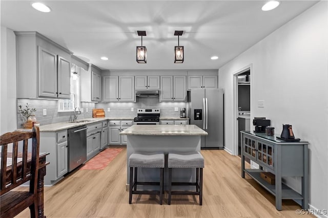3724 Liberty Point Dr, Midlothian, VA 23112 - kitchen featuring appliances with stainless steel finishes, gray cabinetry, under cabinet range hood, a sink, and a center island