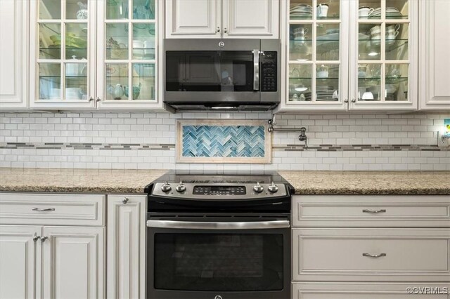 1146 Wicker Dr, Colonial Heights, VA 23834 - kitchen featuring appliances with stainless steel finishes, white cabinets, glass insert cabinets, and backsplash