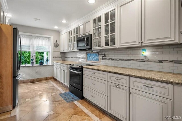 1146 Wicker Dr, Colonial Heights, VA 23834 - kitchen with appliances with stainless steel finishes, white cabinetry, backsplash, glass insert cabinets, and light stone counters