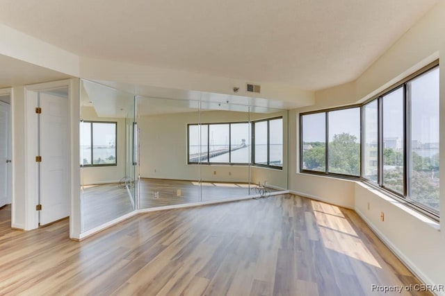 7505 River Rd Unit 4D, Newport News, VA 23607 - empty room featuring wood finished floors, plenty of natural light, and baseboards