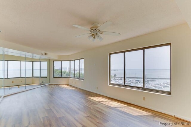 7505 River Rd Unit 4D, Newport News, VA 23607 - unfurnished room with a ceiling fan, wood finished floors, baseboards, and a water view
