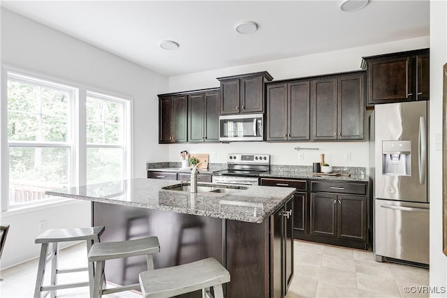 8412 Morocco Pl, Moseley, VA 23832 - kitchen featuring appliances with stainless steel finishes, light stone countertops, a center island with sink, and a kitchen breakfast bar