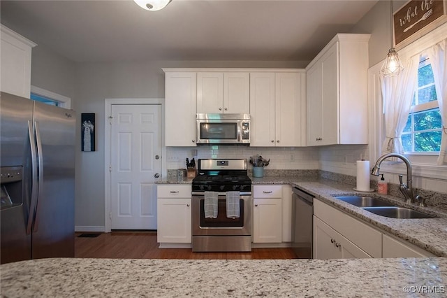 9604 Weston Ln, Henrico, VA 23238 - kitchen featuring appliances with stainless steel finishes, a sink, white cabinets, and light stone countertops