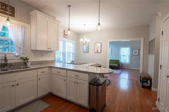 9604 Weston Ln, Henrico, VA 23238 - kitchen featuring a peninsula, white cabinets, dark wood-type flooring, a chandelier, and light stone counters