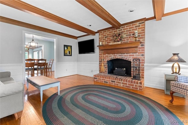 9140 Robin Ridge Dr, Hanover, VA 23116 - living area featuring beamed ceiling, wood finished floors, a wainscoted wall, a chandelier, and a brick fireplace