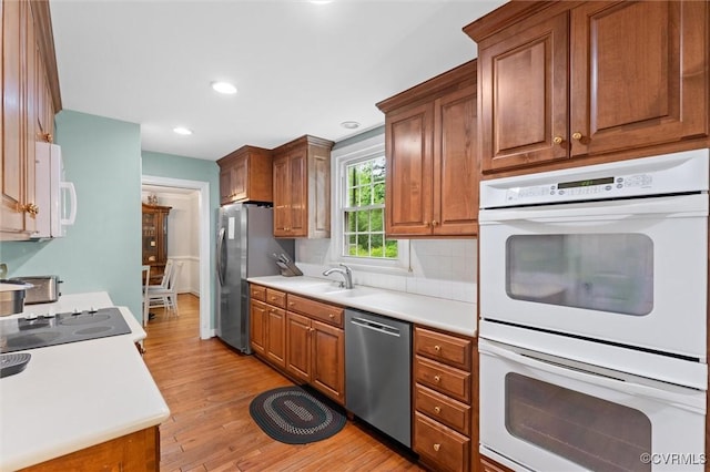 9140 Robin Ridge Dr, Hanover, VA 23116 - kitchen featuring stainless steel appliances, light wood-type flooring, brown cabinetry, light countertops, and tasteful backsplash