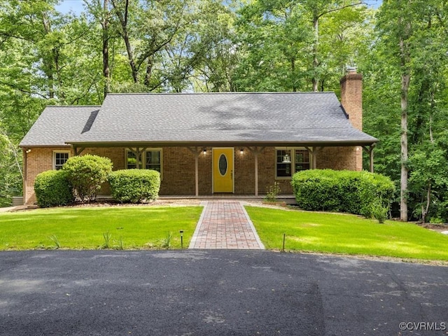 13610 Old Stage Rd, North Prince George, VA 23860 - view of front of home featuring a chimney, a front yard, a shingled roof, and brick siding