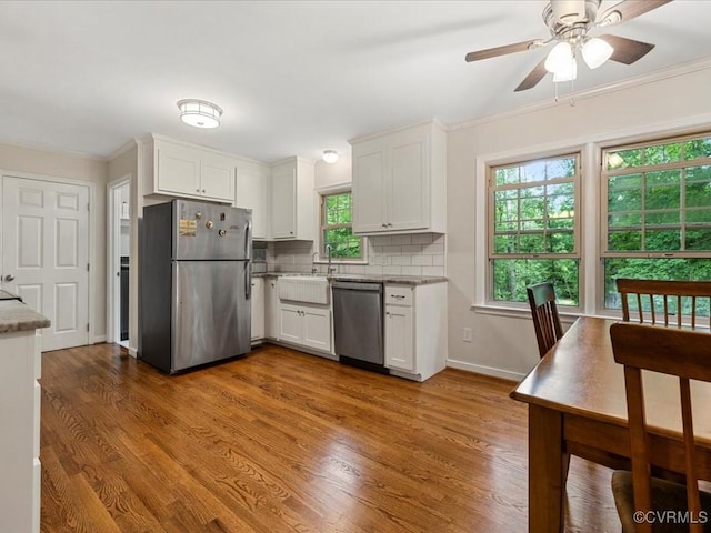 13610 Old Stage Rd, North Prince George, VA 23860 - kitchen featuring appliances with stainless steel finishes, white cabinetry, a sink, backsplash, and ornamental molding