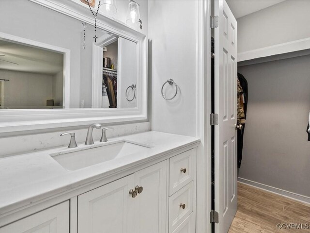 13610 Old Stage Rd, North Prince George, VA 23860 - bathroom featuring vanity, wood finished floors, a walk in closet, and baseboards
