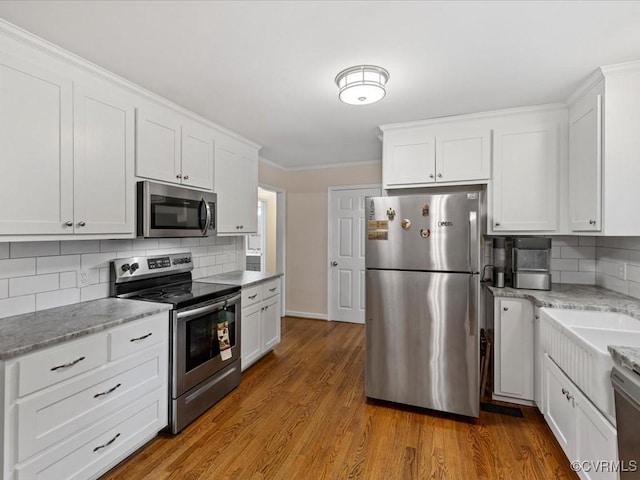 13610 Old Stage Rd, North Prince George, VA 23860 - kitchen featuring appliances with stainless steel finishes, backsplash, white cabinetry, and crown molding