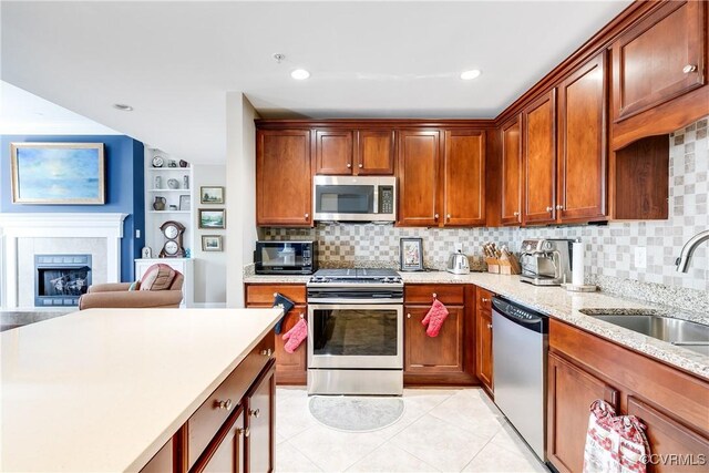 1350 Westwood Ave Unit 406, Richmond, VA 23227 - kitchen with stainless steel appliances, a sink, backsplash, light stone counters, and light tile patterned floors