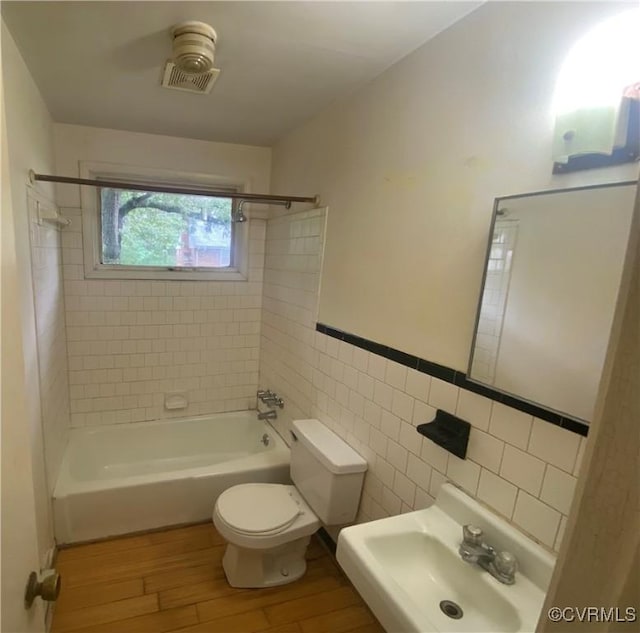 205 N Beech Ave, Henrico, VA 23075 - bathroom with a sink, wood finished floors, toilet, tile walls, and shower / bathtub combination