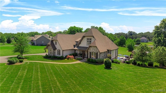 3397 Manor Oaks Dr, Powhatan, VA 23139 - view of front facade with stone siding, a front yard, and view of scattered trees
