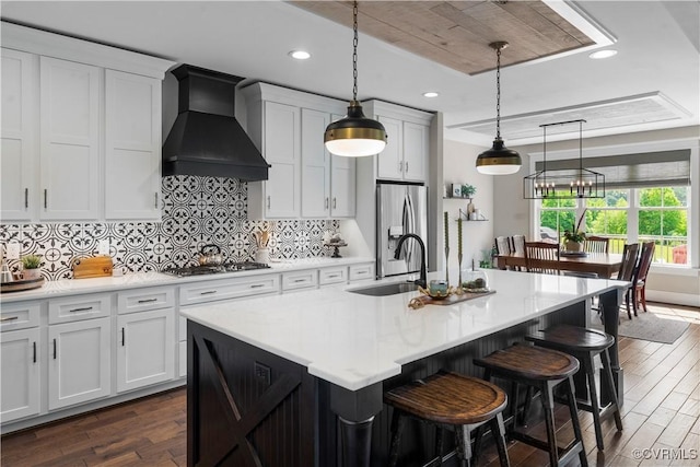 3397 Manor Oaks Dr, Powhatan, VA 23139 - kitchen featuring premium range hood, appliances with stainless steel finishes, dark wood-style flooring, light countertops, and an island with sink