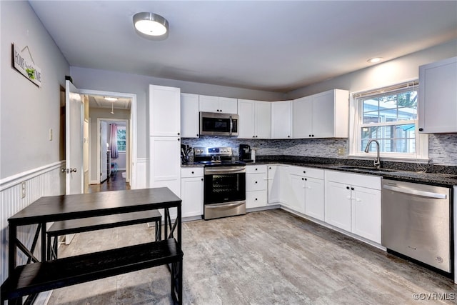 603 Pleasant St, Henrico, VA 23075 - kitchen with appliances with stainless steel finishes, a sink, backsplash, a wainscoted wall, and white cabinets