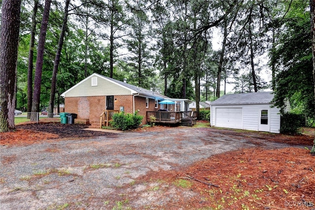603 Pleasant St, Henrico, VA 23075 - view of side of property with an outbuilding, a wooden deck, a detached garage, brick siding, and driveway