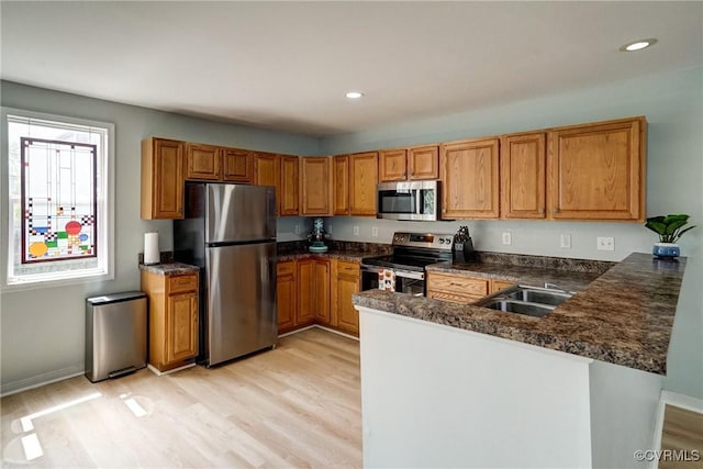 3107 Q St, Richmond, VA 23223 - kitchen with stainless steel appliances, brown cabinetry, light wood-style flooring, a peninsula, and recessed lighting