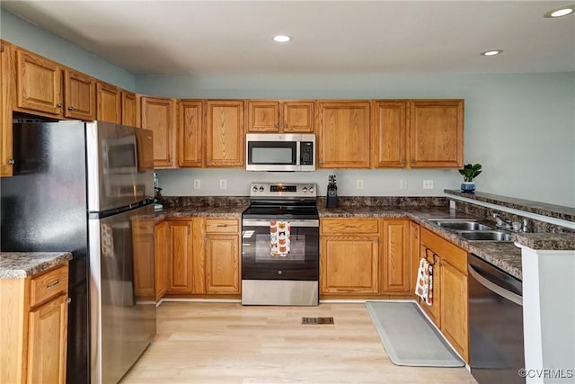 3107 Q St, Richmond, VA 23223 - kitchen with appliances with stainless steel finishes, light wood-type flooring, recessed lighting, and brown cabinetry