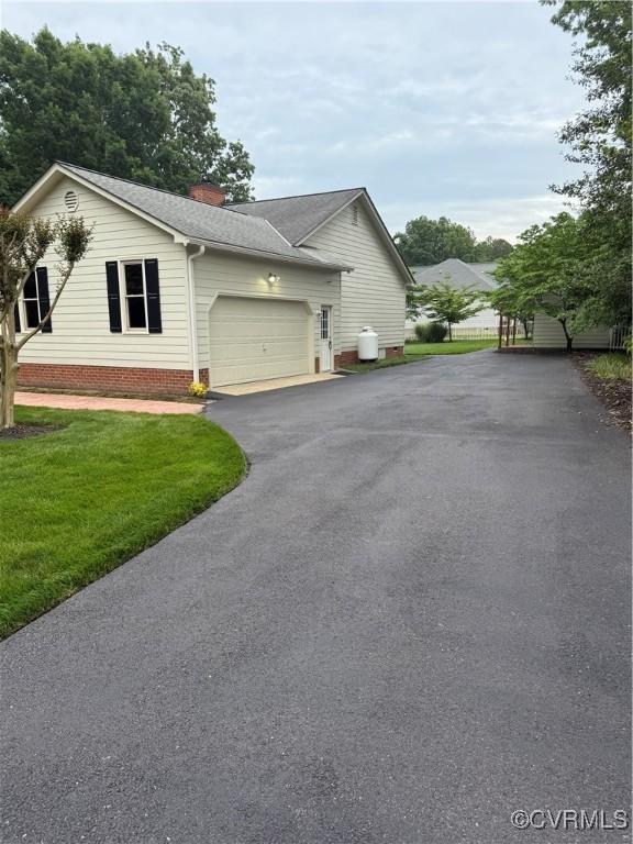 12605 Long Branch Ct, Chesterfield, VA 23832 - view of home's exterior with driveway, a garage, a chimney, a yard, and roof with shingles