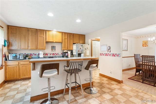 17 Brougham Rd, Fluvanna, VA 22963 - kitchen featuring light flooring, stainless steel fridge, baseboards, a breakfast bar, and recessed lighting