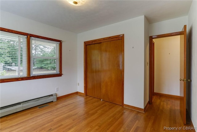 449 Martha Lee Dr, New Market, VA 23666 - unfurnished bedroom with a baseboard heating unit, light wood-type flooring, a closet, and baseboards