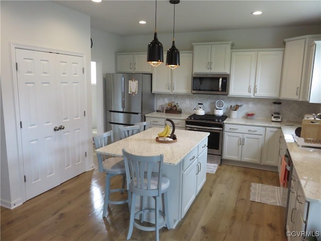 7617 Royal Crown Ct, Mechanicsville, VA 23116 - kitchen featuring stainless steel appliances, tasteful backsplash, white cabinets, a kitchen island, and a breakfast bar area
