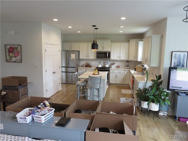 7617 Royal Crown Ct, Mechanicsville, VA 23116 - kitchen featuring stainless steel appliances, light countertops, a sink, light wood-type flooring, and recessed lighting