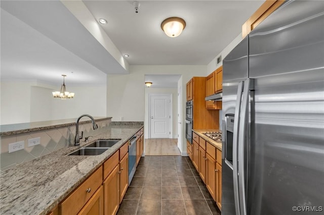 4250 Granby St Unit 105, Norfolk, VA 23504 - kitchen featuring stainless steel appliances, a sink, brown cabinetry, backsplash, and a chandelier