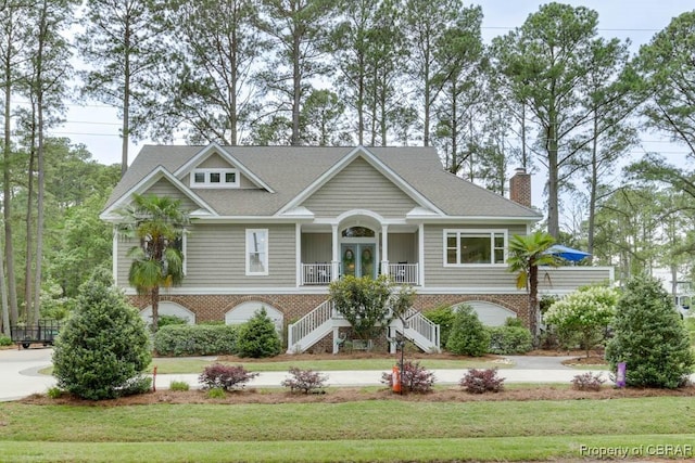 109 Vreeland Dr, Yorktown, VA 23692 - view of front of home with stairway, brick siding, a front lawn, a porch, and a chimney