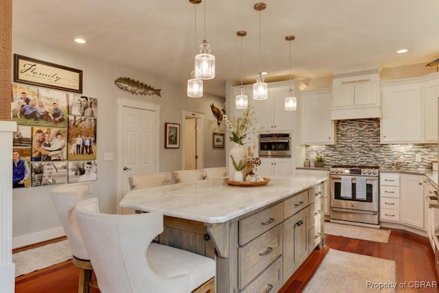 109 Vreeland Dr, Yorktown, VA 23692 - kitchen with stainless steel appliances, dark wood-style floors, a kitchen bar, decorative backsplash, and a kitchen island