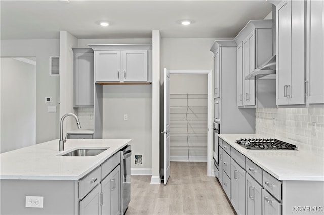 16831 Barmer Rd, Chesterfield, VA 23838 - kitchen with appliances with stainless steel finishes, a sink, light wood-style flooring, backsplash, and an island with sink