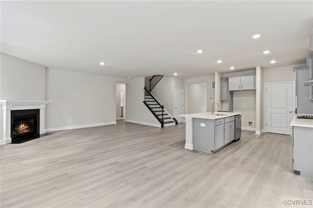 16831 Barmer Rd, Chesterfield, VA 23838 - kitchen with a sink, light countertops, open floor plan, light wood finished floors, and gray cabinetry