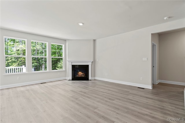 16831 Barmer Rd, Chesterfield, VA 23838 - unfurnished living room with baseboards, light wood-style floors, and a fireplace with flush hearth