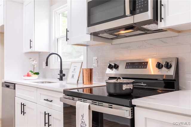 2214 Parkside Ave, Henrico, VA 23228 - kitchen with stainless steel appliances, a sink, white cabinets, light countertops, and tasteful backsplash
