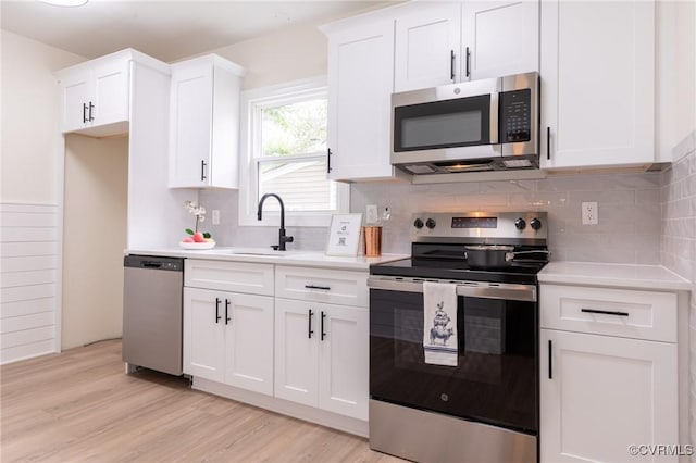 2214 Parkside Ave, Henrico, VA 23228 - kitchen with stainless steel appliances, light countertops, white cabinetry, and light wood-type flooring