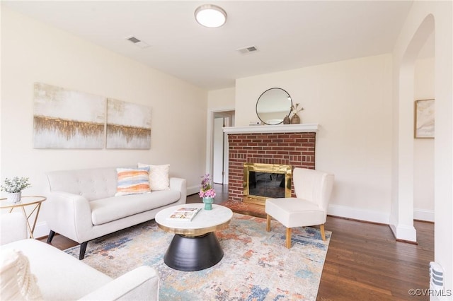 2214 Parkside Ave, Henrico, VA 23228 - living room featuring wood finished floors, a brick fireplace, arched walkways, and baseboards